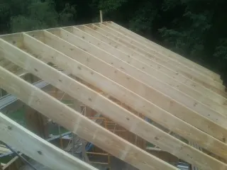 New roof rafters set over an addition before sheathing in Peterman